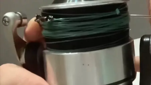 Carrete de un reel frontal cargado con multifilamento verde, en la mano