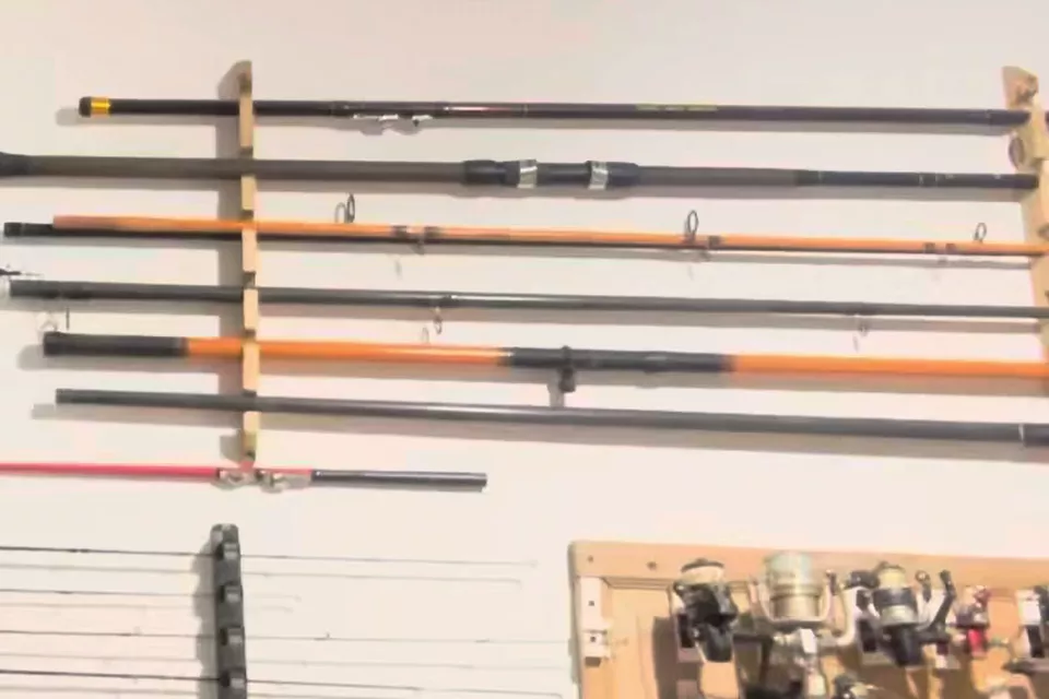Cañas en un rack de madera y reels en un tablero, colgados en una pared